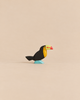 Handmade Holzwald Bird - Toucan figurine with a black body, yellow chest, and colorful beak standing on a blue base.
