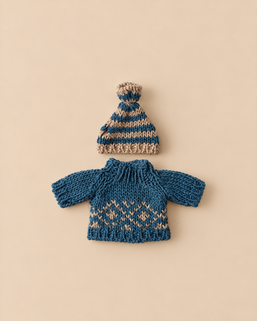 A blue and tan striped knit hat sits above a blue sweater featuring a tan Scandinavian geometric pattern for the Maileg Extra Clothing: Knitted Sweater And Hat for Dad Mouse.