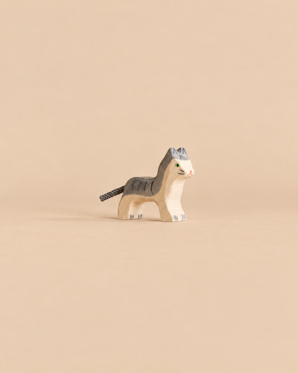 Holztiger Cat, Small, a handcrafted wooden toy cat with gray stripes and a cord tail.