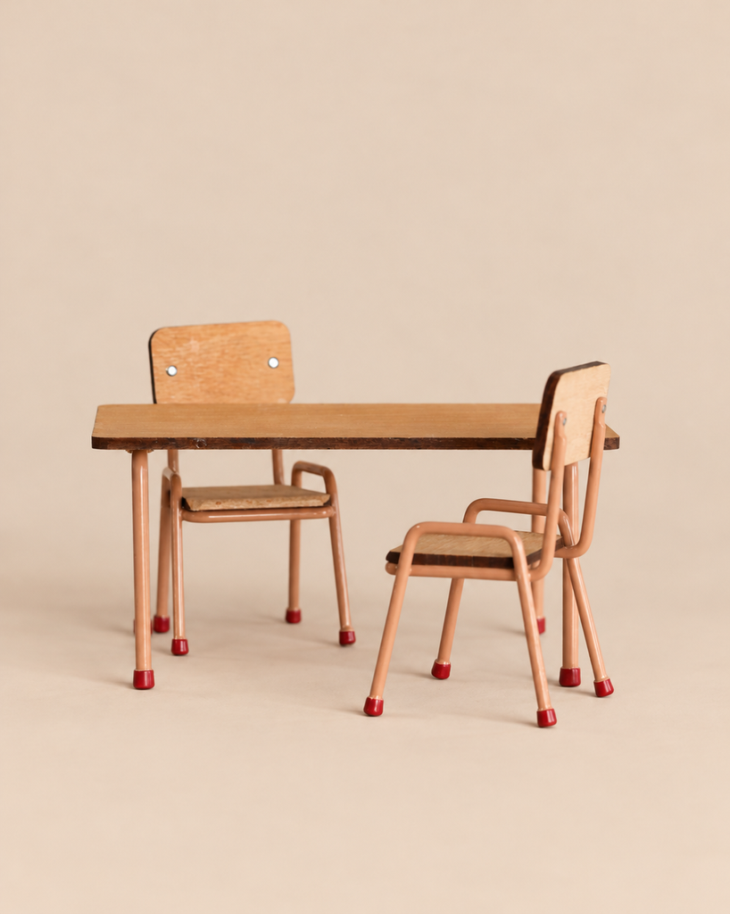 The Maileg Family Breakfast Set includes a miniature table and two matching chairs with wooden seats and tabletops and light-colored metal frames.