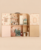 The Maileg Suitcasa Furnished Set opens to reveal a mouse dollhouse with two floors, a bed, kitchen appliances, a small chair, a table, and bathroom fixtures.