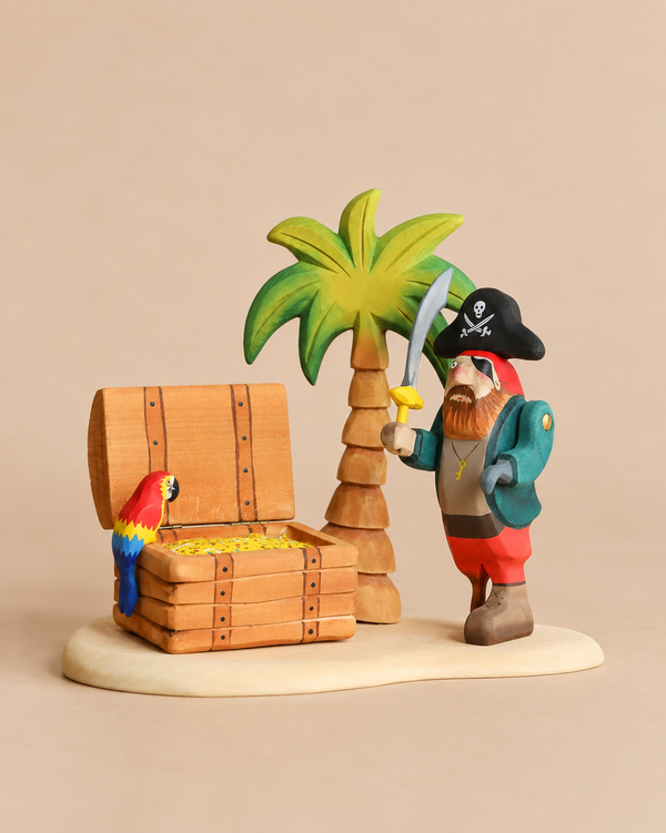The Bumbu Handmade Wooden Treasure Hunt Set features a handcrafted wooden pirate figurine holding a sword beside a treasure chest filled with gold coins, a palm tree, and a colorful parrot.