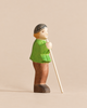 Handmade Holzwald Shepherd & Farm Animals Set shepherd figurine in a green shirt and brown pants holding a long staff.