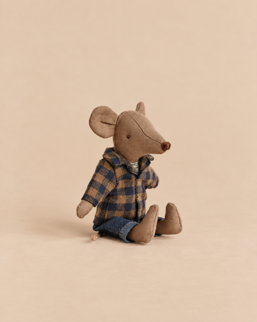 A light brown Maileg Dad Mouse In Brown Checkered Shirt sits wearing a dark blue and brown checkered shirt over blue pants.