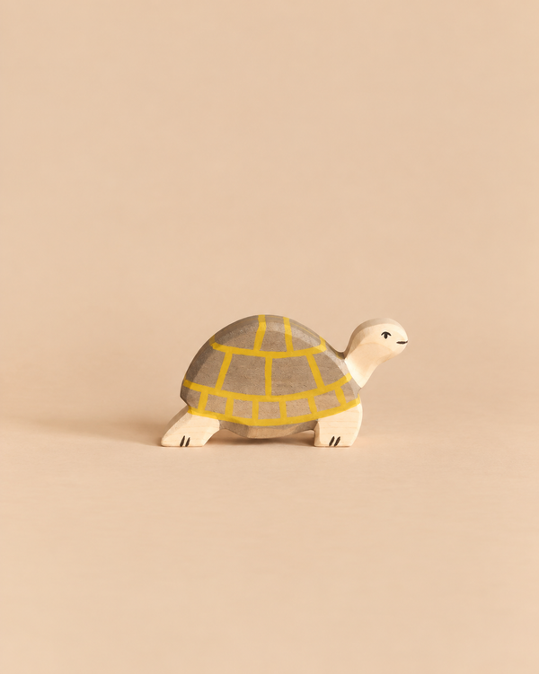 Holztiger Tortoise, a handcrafted wooden toy with a grey shell featuring a yellow grid pattern, perfect for open-ended play.