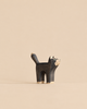 A small, stylized Handmade Holzwald Black Cat figure made of wood, painted black with light-colored paws and face details.