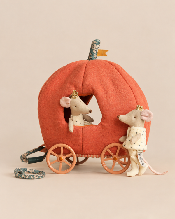Two royal twin mice wearing small gold crowns from the Maileg Royal Pumpkin Carriage Set, with one sitting inside an orange pumpkin-shaped carriage and one standing beside it.