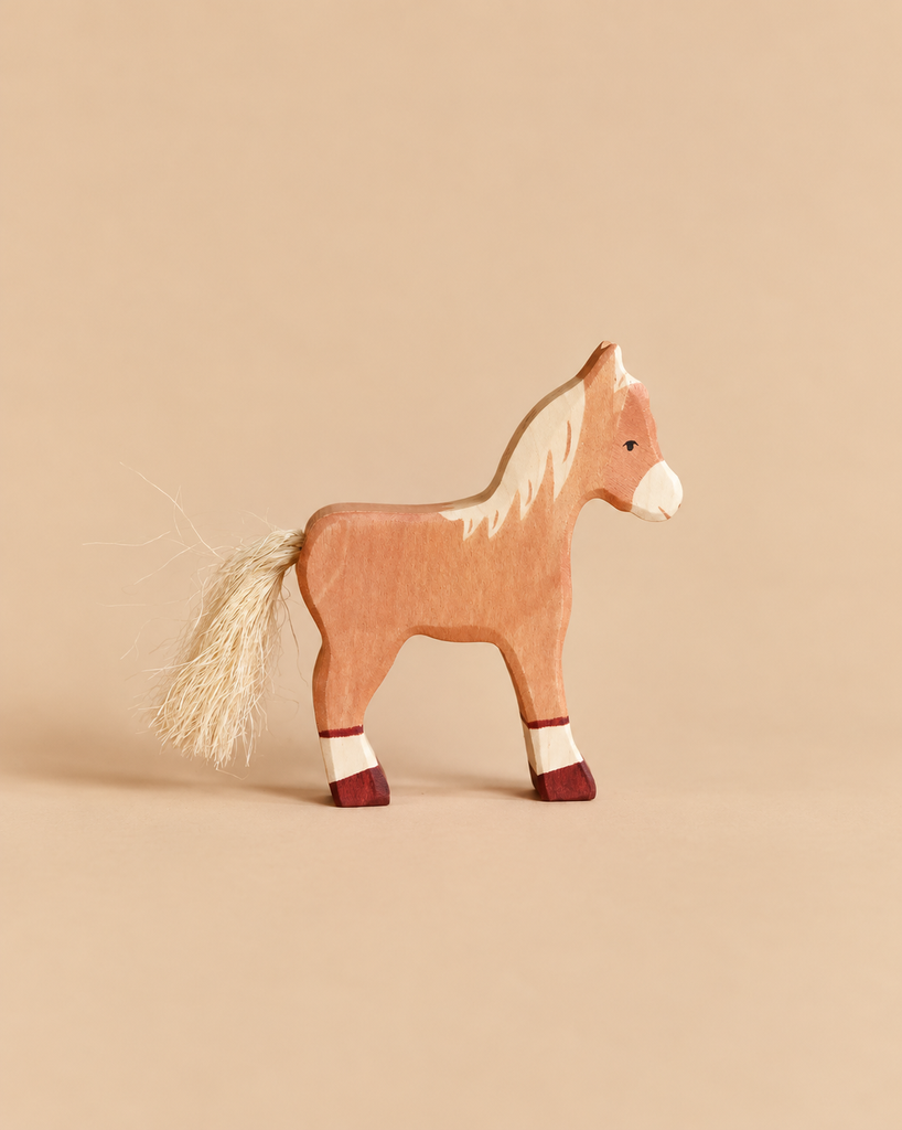 A handcrafted wooden Holztiger Horse Foal, Standing with a light-colored mane and tail, standing on four dark-tipped legs.