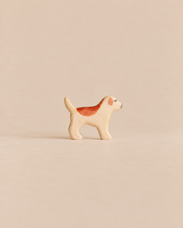 Handmade Holzwald Dog - Golden Retriever Puppy, a small, sustainable wooden toy figure of a standing dog with a brown patch on its back and eye.