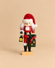 Christian Ulbricht Collectible Wooden Nutcracker - Santa with Lantern wearing a red suit and hat, holding a lantern in one hand and a green toy sack in the other.