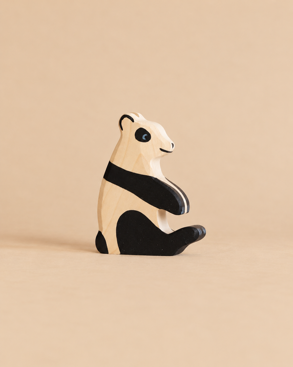 A Holztiger Panda Bear, Sitting, handcrafted from wood and shown in profile with black and natural wood markings.