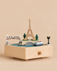 A Paris Music Box featuring a miniature Eiffel Tower, a bridge, a boat, and a lamp post on its top surface.
