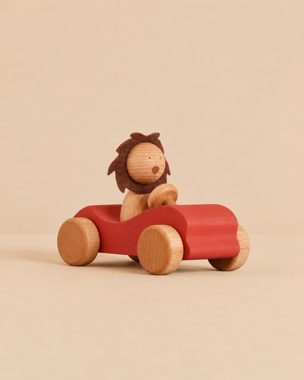 Sabo Concept Car with Lion featuring a wooden toy lion with a felt mane driving a small red developmental toy car.