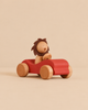 Sabo Concept Car with Lion featuring a wooden toy lion with a felt mane driving a small red developmental toy car.