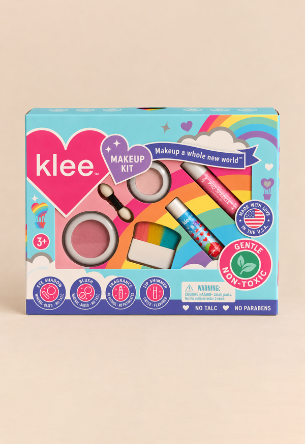 The Klee Naturals Makeup Kit - After the Rain- Rainbow Dream is a rainbow-themed box containing non-toxic mineral makeup, including blush, eyeshadow, a dual-ended applicator, a blush brush, and two lip shimmer tubes.