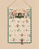 Nativity Embroidered Hanging Advent Calendar with numbered pockets from 1 to 25, decorated with embroidered scenes, angels, and botanical motifs, featuring a hanging angel ornament on a string.