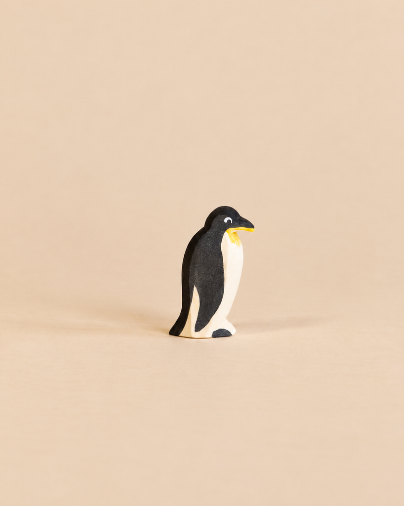 An Ostheimer Penguin - Head Straight is a small, handcrafted wooden figurine with a black back and white chest designed for imaginative play.