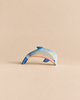 An Ostheimer Dolphin, Head Low wooden toy painted in shades of blue and pink, positioned with its head pointed downward.