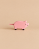Small pink handcrafted Holztiger Piglet wooden toy with black hooves and a textured tail.