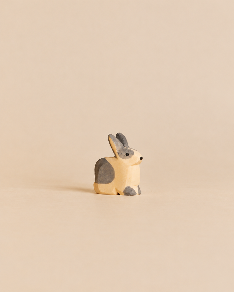 Ostheimer Black & White Rabbit - Sitting in a handcrafted wooden design, depicted in a sitting position with painted grey and natural wood markings.