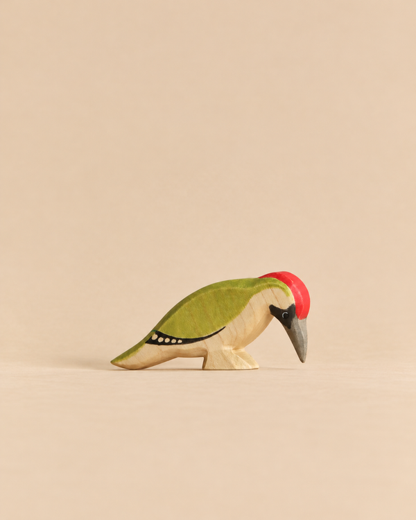 Handmade Holzwald Bird - Woodpecker figurine for imaginative play, featuring a green back, red crest, and dark grey beak.