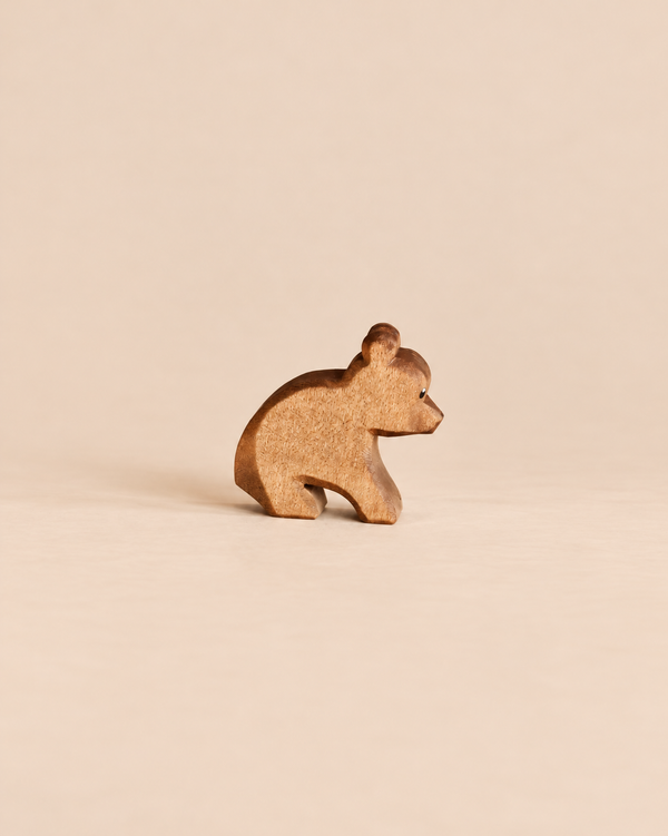 Ostheimer Small Bear - Sitting, a handcrafted wooden toy bear in a sitting position, perfect for imaginative play.