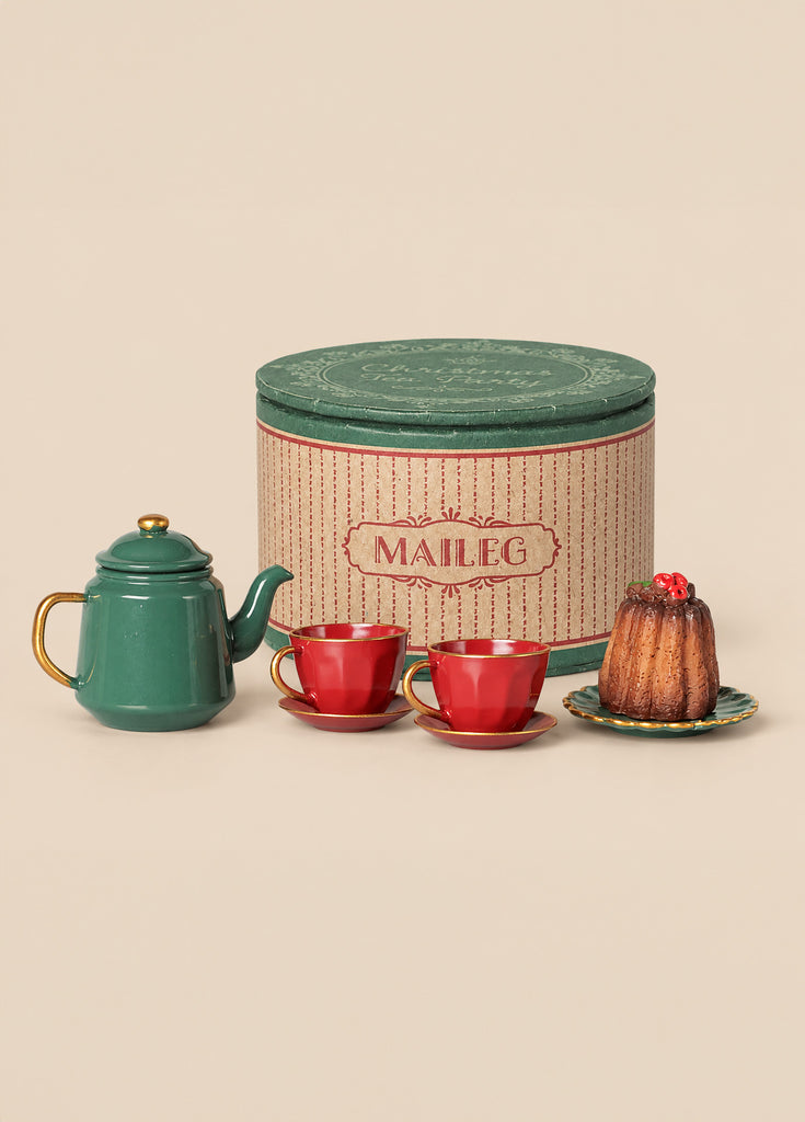 A Maileg Christmas Tea With Grandma Set featuring a green teapot, two red teacups on saucers, and a small bundt cake on a plate, displayed in front of a round green Maileg storage box.