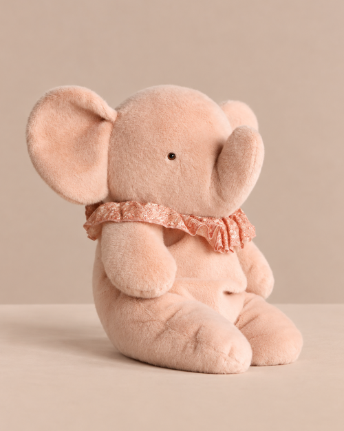 A soft pink Maileg Elephant Plush, Big - Powder sitting upright, wearing a ruffled lace collar as a charming stuffed animal.