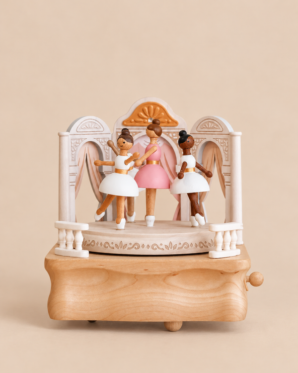A Ballerina Music Box featuring three dancing ballerina figurines on a wooden stage set with decorative arches.