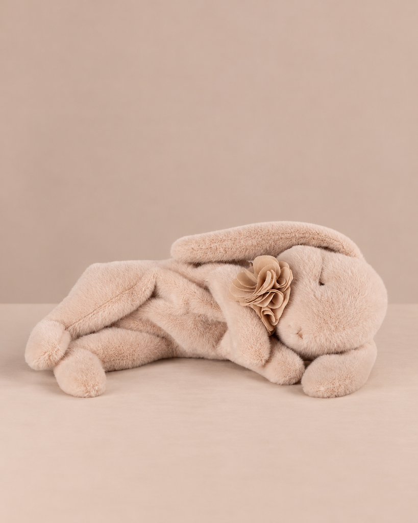 Maileg Plush Sleeping Bunny - Powder lying down with its eyes closed, wearing a fabric flower collar.