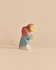 Hand-painted Ostheimer Witch wooden figurine of a stooped figure wearing a pink hood and blue cloak.