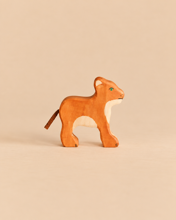 Handcrafted Holztiger Lion Cub wooden toy with a natural wood finish and a cord tail.