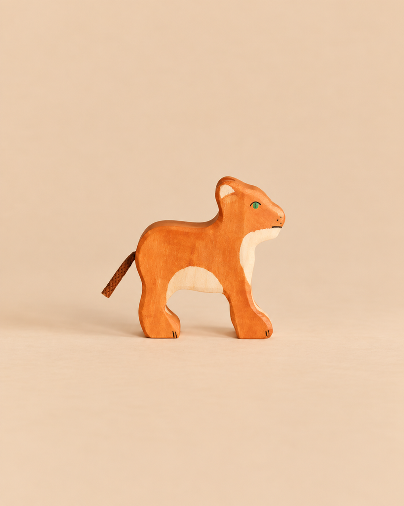 Handcrafted Holztiger Lion Cub wooden toy with a natural wood finish and a cord tail.