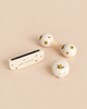 Konges Sloejd Petit Music Set - Glossy Lemon including a harmonica, a maraca, and a castanet, all crafted as wooden music instruments with a cream-colored finish and lemon patterns.