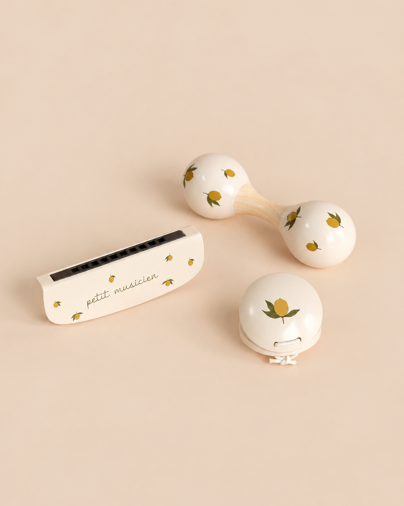Konges Sloejd Petit Music Set - Glossy Lemon including a harmonica, a maraca, and a castanet, all crafted as wooden music instruments with a cream-colored finish and lemon patterns.
