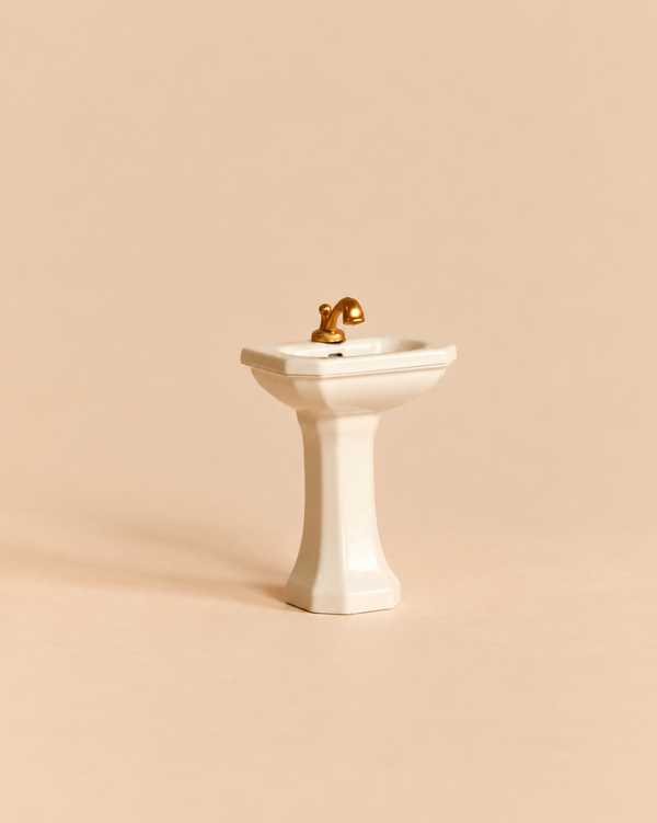 Maileg Bathroom Sink, Mouse Size - Off White, featuring a miniature white pedestal design with a gold-colored faucet, created as a charming mouse house accessory.