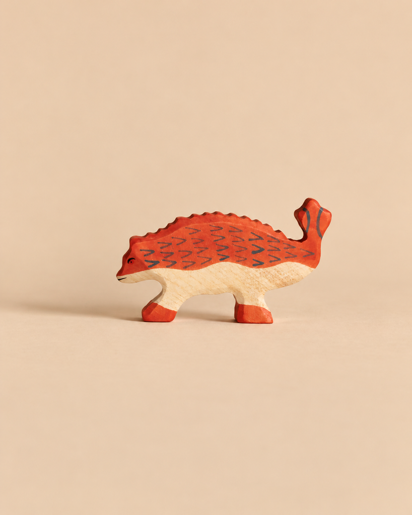 Handcrafted wooden Holztiger Ankylosaurus Dinosaur with a red back and tail, patterned with dark chevron markings.