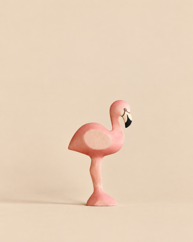 A Handmade Holzwald Bird - Flamingo figurine in shades of pink with a black and white beak.