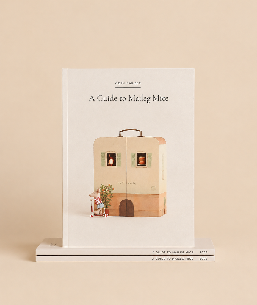Odin Parker’s Maileg Catalog, a hardbound guide featuring an illustration of a mouse on a scooter in front of a suitcase house.