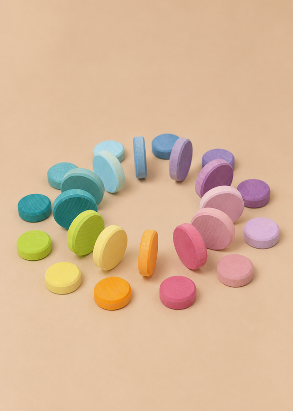 A circular arrangement of Grimm’s Wooden Pastel Coins and stacking rollers in a flat gradient.