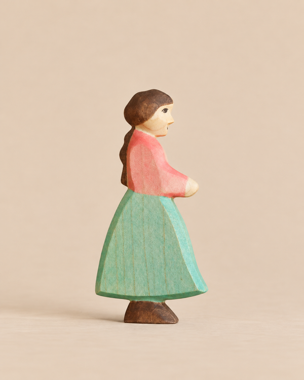 Handmade Holzwald Goose Girl figurine, hand-carved from wood as a girl in a pink top and green skirt for imaginative play.