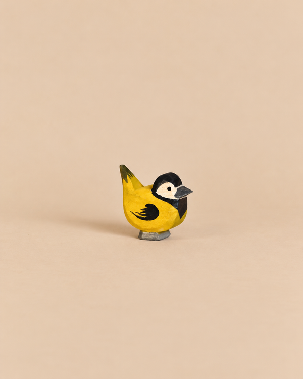 Handcrafted wooden Ostheimer Bird - Goldfinch with a yellow breast, black head markings, and white cheek patches.