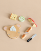 A Cheese Chopping Board set including a mouse-shaped cutting board, a toy knife, and wooden food pieces like cheese, a bread loaf, and a rolled pastry for a kids’ play kitchen.