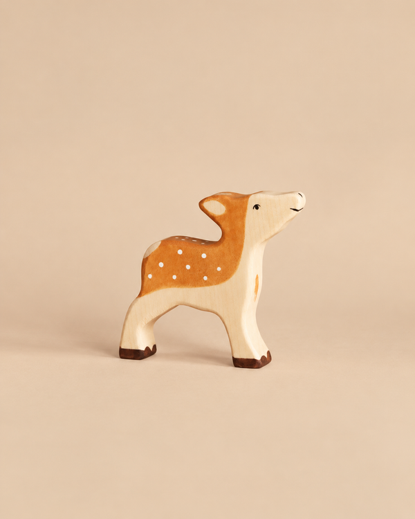 Holztiger Fawn handcrafted wood toy with a light tan body, white spots on its back, and dark brown hooves.
