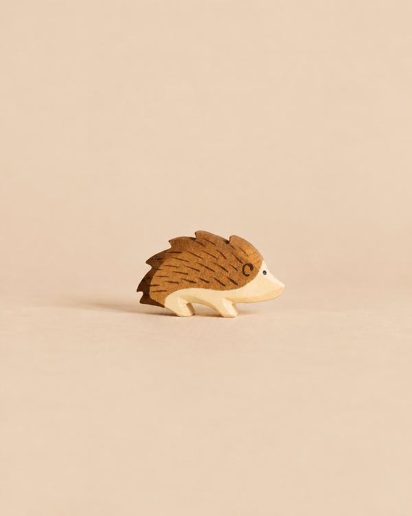 An Ostheimer Hedgehog handcrafted from wood, featuring brown painted quills and a light wood face, perfect for imaginative play.