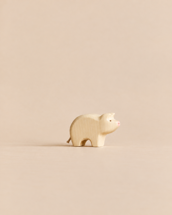 Handmade Holzwald Piglet, a small wooden toy with a painted pink snout.