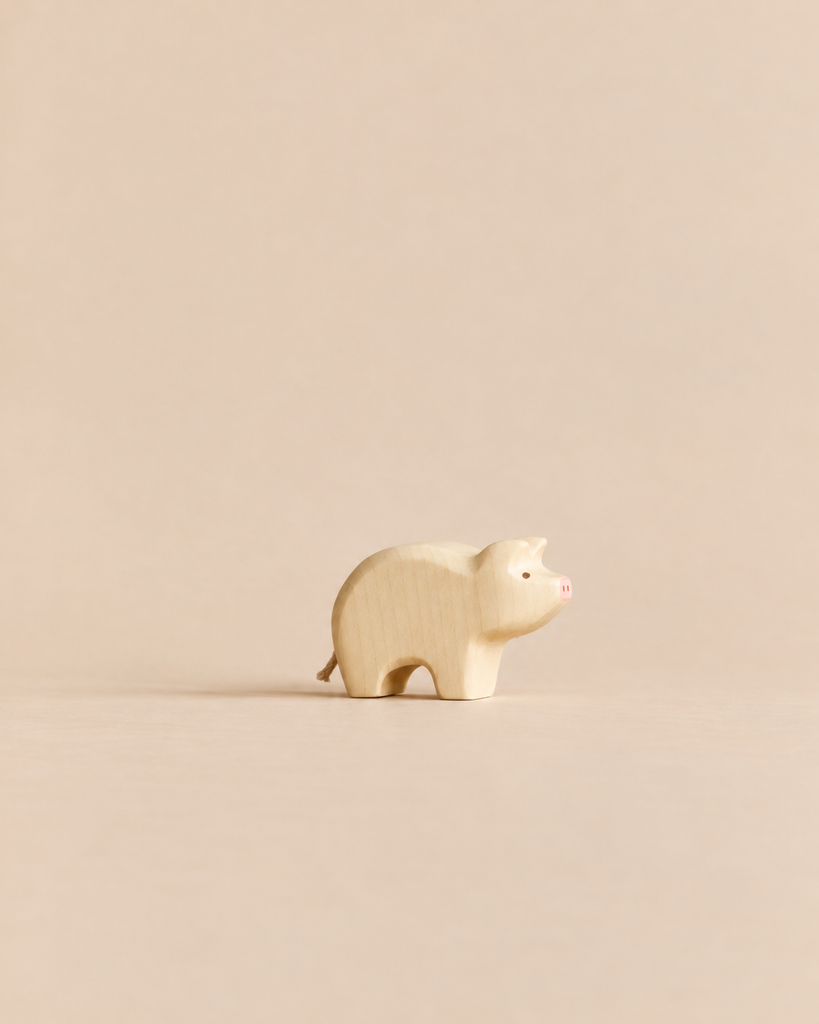 Handmade Holzwald Piglet, a small wooden toy with a painted pink snout.