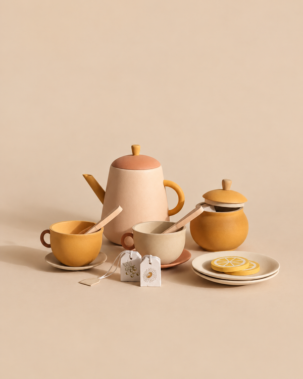 A Sabo Concept Handmade Wooden Tea Set - Flower including a teapot, two cups with spoons, a lidded sugar bowl, two tea bags, and lemon slices on plates.