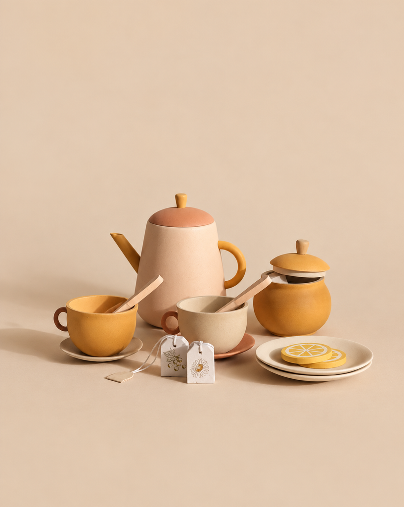 A Sabo Concept Handmade Wooden Tea Set - Flower including a teapot, two cups with spoons, a lidded sugar bowl, two tea bags, and lemon slices on plates.