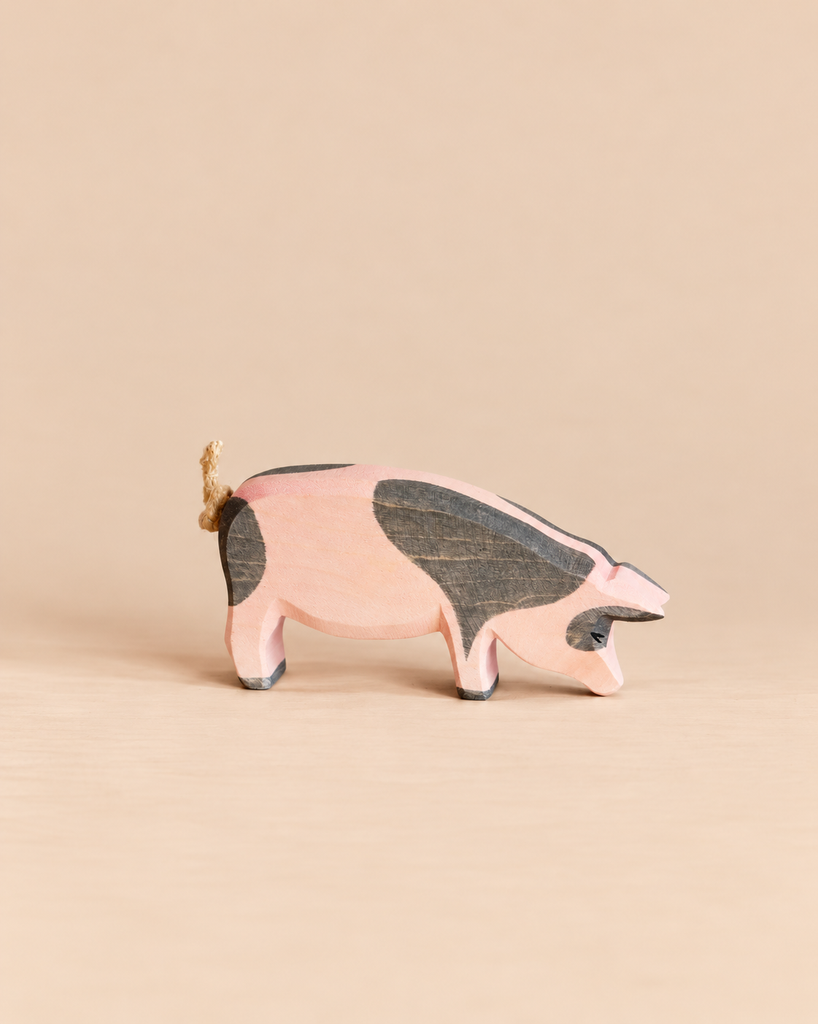 Ostheimer Spotted Pig - Head Low hand-carved wooden figurine with pink and grey spots and a rope tail.
